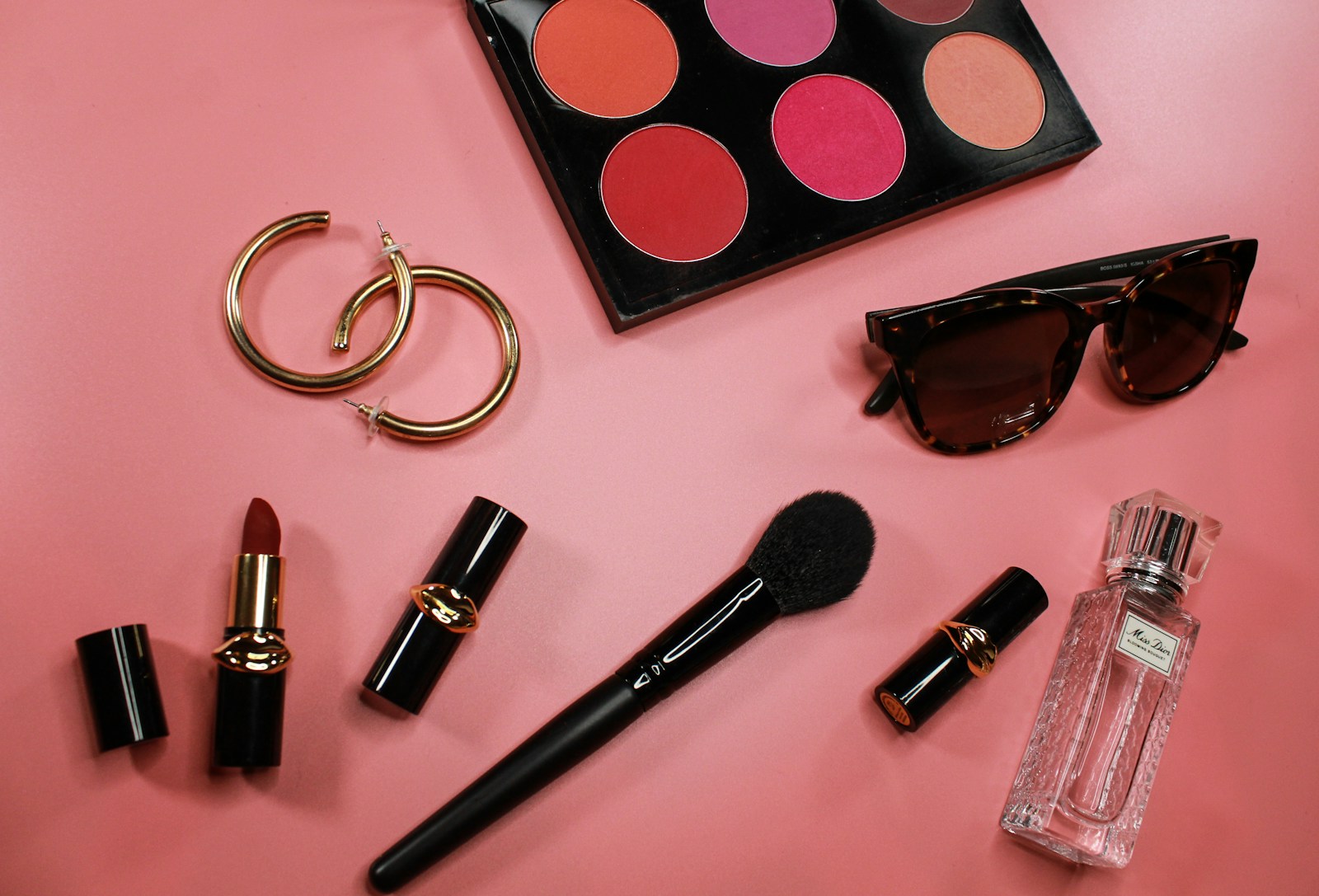 black and pink lipstick on pink surface
